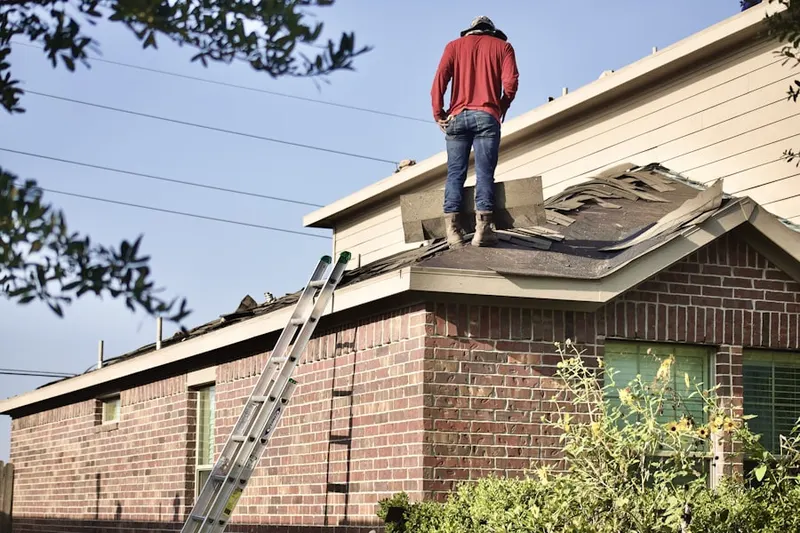 Professional roofer working on a residential roof in Branson